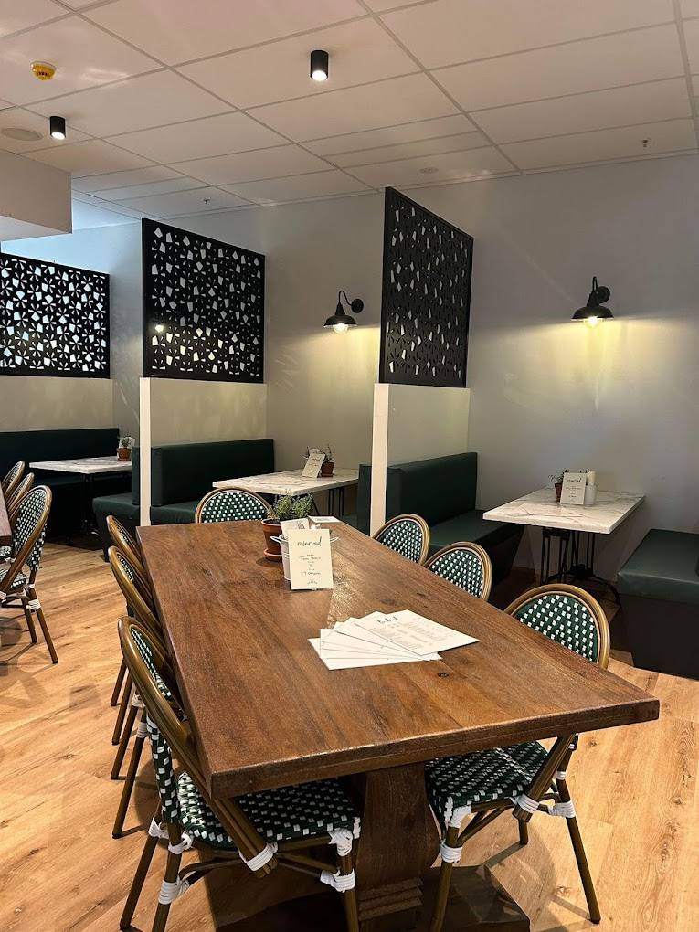 The back room, with booth seating and a long timber table set for a group.