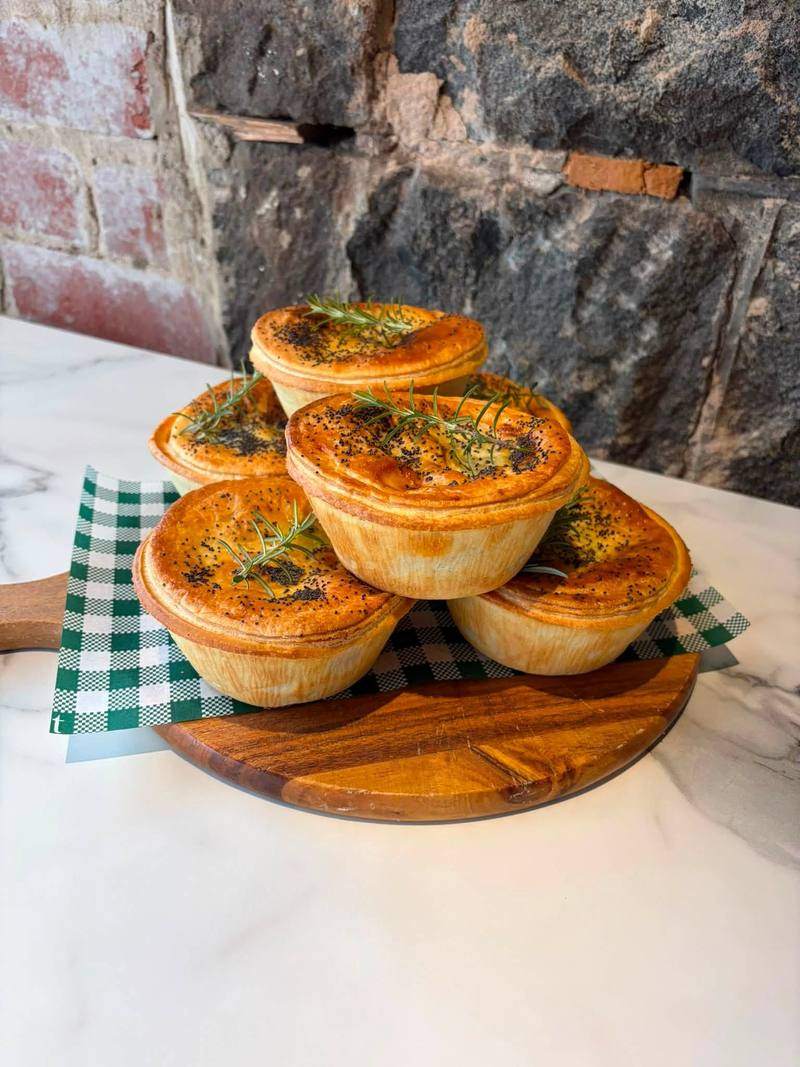 Pies stacked on a wooden board.